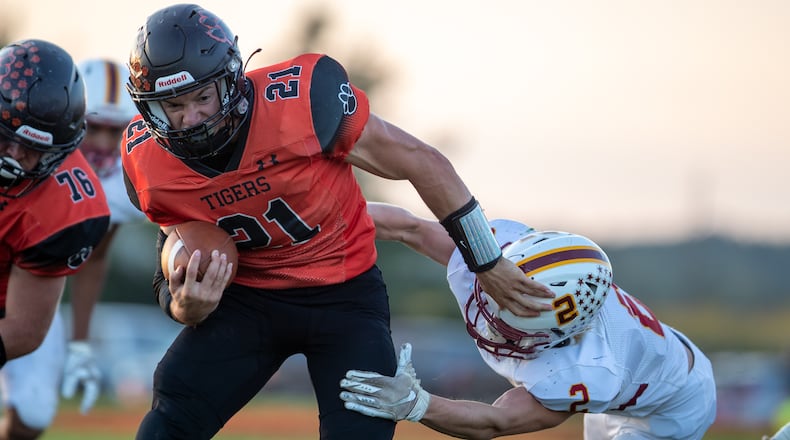 West Liberty-Salem High School senior Gabe McGill stiff arms Northeastern senior Johnny Jones during their game on Friday night at Tiger Stadium in West Liberty. The Tigers won 42-7. Michael Cooper/CONTRIBUTED