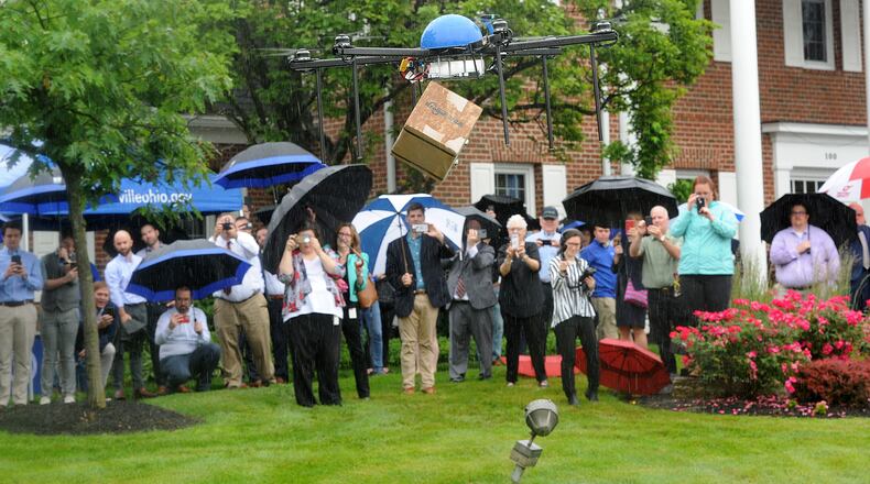 The Kroger Co. took flight with its first retail drone delivery Wednesday morning, June 9, 2021 in Centerville, flying a box containing two packages of long-grain rice and a piece of wood from the first Wright Brothers Flyer to Centerville Mayor Brooks Compton on the front lawn of city offices on West Spring Valley Pike. MARSHALL GORBY\STAFF