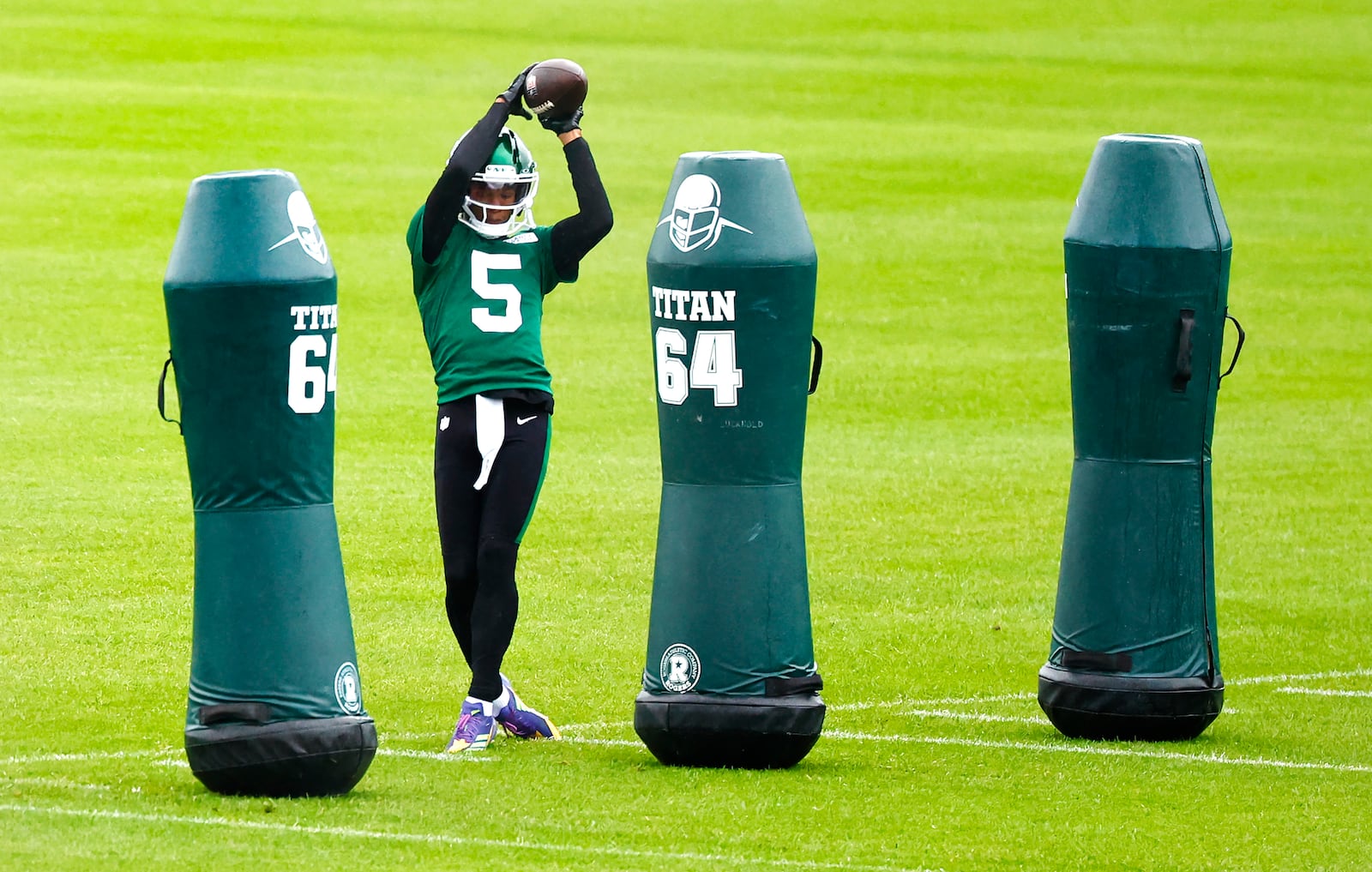 New York Jets wide receiver Garrett Wilson (5) catches a pass during NFL football practice, Wednesday, May 21, 2025, in Florham Park, N.J. (AP Photo/Noah K. Murray