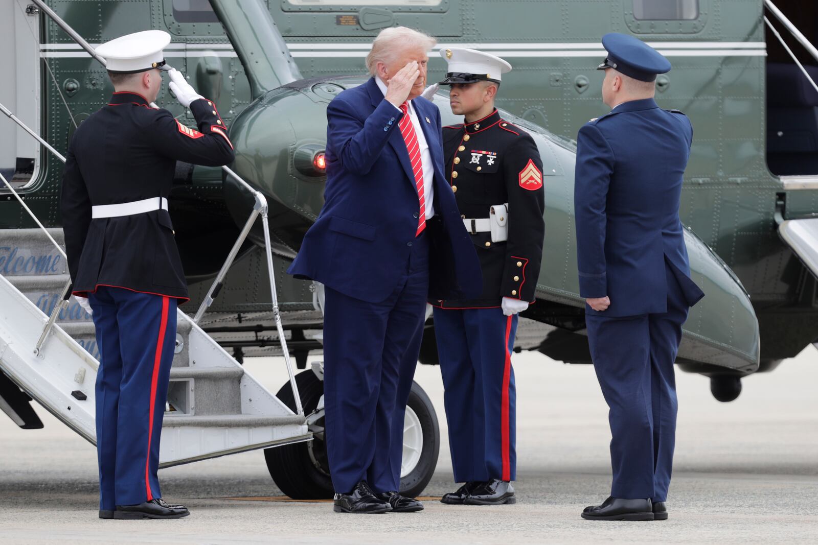 President Donald Trump, center, is greeted by Col. Paul Pawluk, Vice Commander, 89th Airlift Wing, right upon his arrival at Joint Base Andrews, Md., Friday, May 30, 2025. (AP Photo/Luis M. Alvarez)