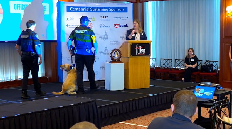 Hamilton City Schools will be the benefactor of Leadership Hamilton Class 33's project called Pawsitive Connections, which will place a therapy dog in the Hamilton City Schools. Associate Superintendent Andrea Blevins said the goal is to have a therapy dog in each of the 13 district buildings. Pictured are Hamilton police officers with a dog during the Leadership Hamilton Class 33 graduation at the Fitton Center on May 21, 2025. PROVIDED/TVHAMILTON