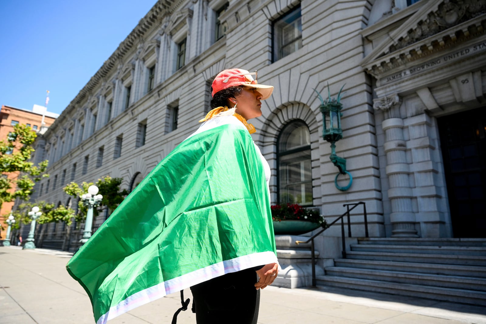 A demonstrator stands outside the 9th U.S. District Court of Appeals before a hearing regarding control of National Guard troops Tuesday, June 17, 2025, in San Francisco. (AP Photo/Noah Berger)