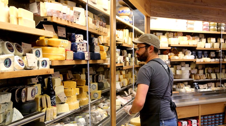 Michael Coffey, a specialty team leader for Whole Foods in Philadelphia, prepares the cheese department Tuesday for opening day. The new Whole Foods store will open today at 9 a.m. The 45,000-square-foot store will feature a coffee bar and beer growler fill-up station, a lunch, soup and salad bar and a cheese department with anitipasti, olive and pickle bars. LISA POWELL / STAFF