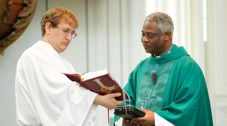 Cardinal Peter Turkson of Ghana (right) presided over a Mass at the University of Dayton's Immaculate Conception Chapel in 2012. At left attending to the service is Will Marsh a recent UD graduate.