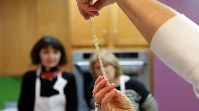 Teacher Margi Kahn demonstrates the elasticity of the bialy dough during the bagels and bialys class on Monday, Jan. 30, 2017, at the Kitchen Conservatory in Clayton, Mo. (Laurie Skrivan/St. Louis Post-Dispatch/TNS)
