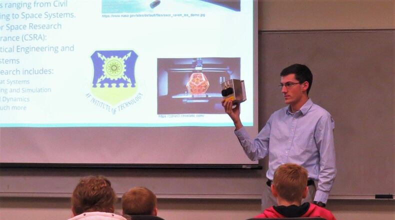 Air Force Institute of Technology astronautical engineering graduate student William Gallagher shows local students interested in space an example of CubeSat hardware from the Center for Space Research and Assurance. The mission shown is scheduled to launch in 2019. (U.S. Air Force photo/Jaclyn Knapp)