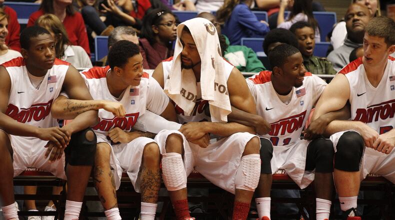 Dayton players lock arms on the bench during the final seconds of their game against IPFW on Saturday, Nov. 9, 2013, at UD Arena. David Jablonski/Staff