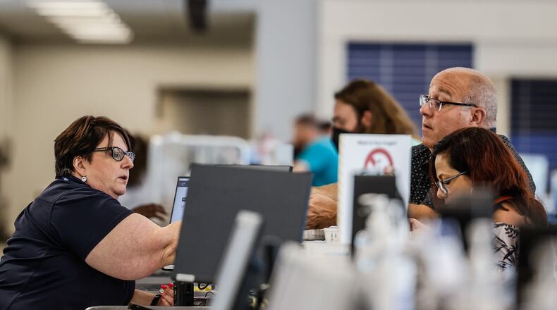 Travelers at the Dayton International Airport check in at a ticket counter before traveling Friday July 15, 2022. JIM NOELKER/STAFF