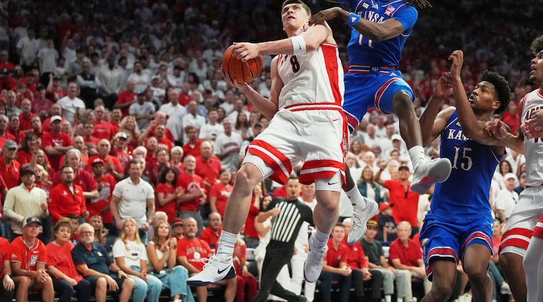 Kansas guard Jamari McDowell (11) fouls Arizona forward Ivan Kharchenkov (8) during the second half of an NCAA college basketball game Saturday, Feb. 28, 2026, in Tucson, Ariz. (AP Photo/Rick Scuteri)
