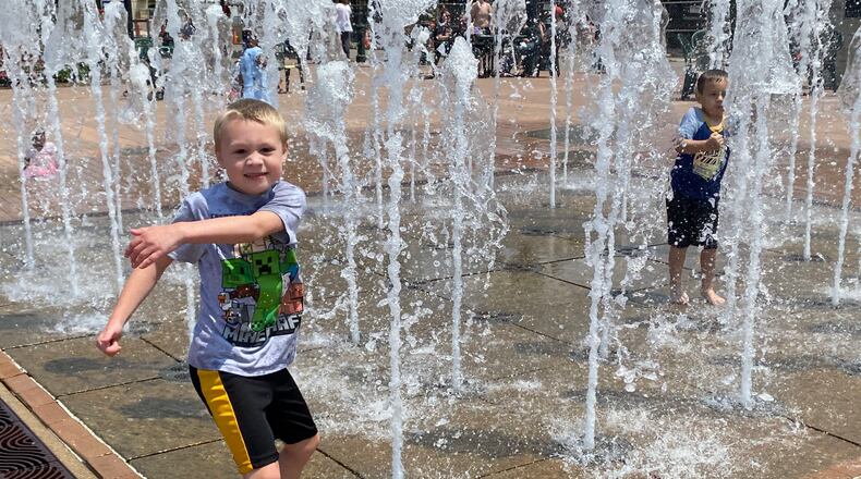 Sebastian Hartman, 7, plays in the water fountain at RiverScape MetroPark in downtown Dayton on Saturday. Eileen McClory / Staff