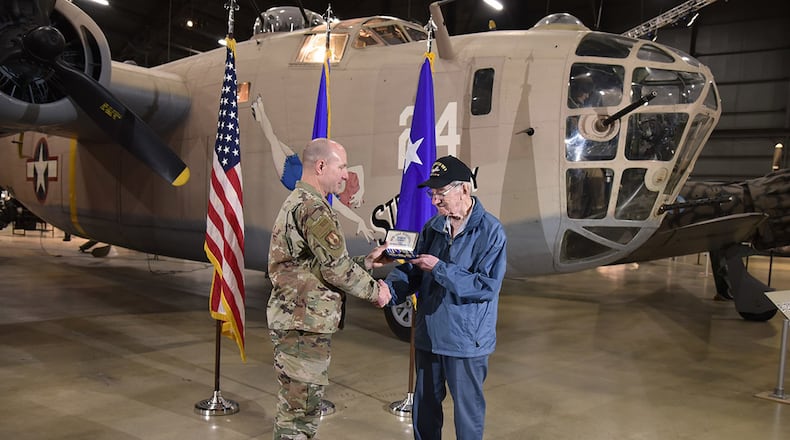 Maj. Gen. Carl Schaefer, Air Force Materiel Command deputy commander, presents service medals to 97-year-old World War II veteran 1st Lt. Joseph Kollenberg at the National Museum of the United States Air Force July 24. Schaefer presented Kollenberg with the Distinguished Flying Cross, the Air Medal with three Oak Leaf Clusters, and the European, African and Middle Eastern campaign service medals to replace those misplaced in the 70 years since the veteran left active-duty service. (U.S. Air Force photo/Ken LaRock)