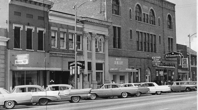The Flash Restaurant, housed in the building, was a staple of downtown Troy for many decades. It and neighboring businesses are shown in this photograph circa 1964. This building was grafted onto the front of the old Miami County courthouse in 1902.