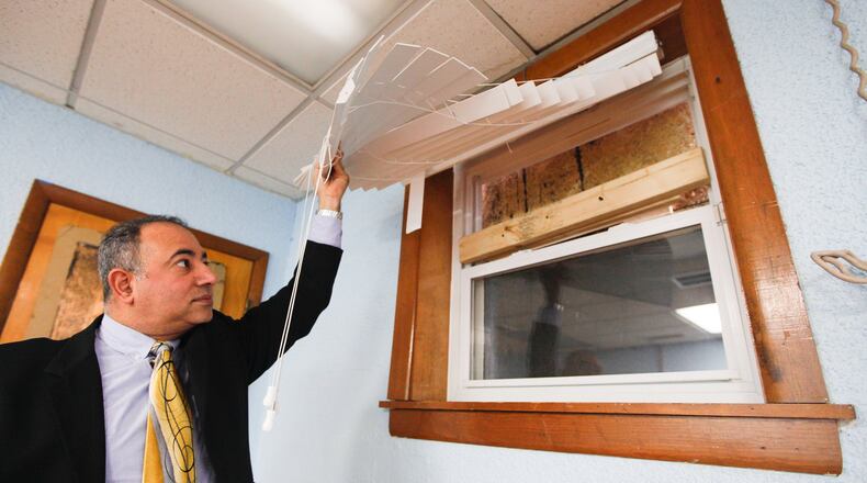 Ayman Salem, vice chairman of the Islamic Society of Greater Dayton, displays a window damaged by a vandalism incident at the Al-Rahman Mosque. CHRIS STEWART / STAFF