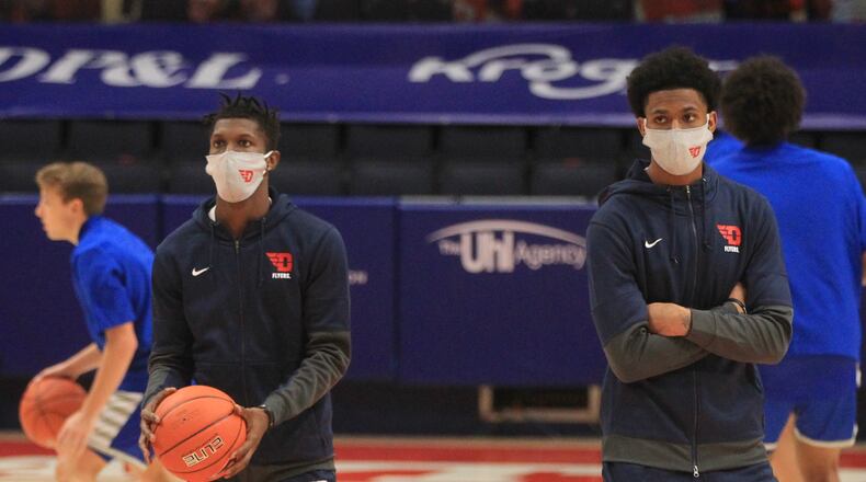 Dayton's Dwayne Cohill and Elijah Weaver watch the team warm up before a game against Eastern Illinois on Tuesday, Dec. 1, 2020, at UD Arena. David Jablonski/Staff