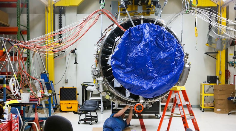 Engineers work on a LEAP commercial jet test engine at GE Aviation in Evendale, Friday, Dec. 19, 2014. The engine, made by CFM, a joint venture between GE and French manufacturer Snecma, will be more fuel efficient and contain advanced materials, and will be transformative for the manufacturing industry because it will contain the first mass-produced 3-D manufactured/additive component in a critical area. GREG LYNCH / STAFF