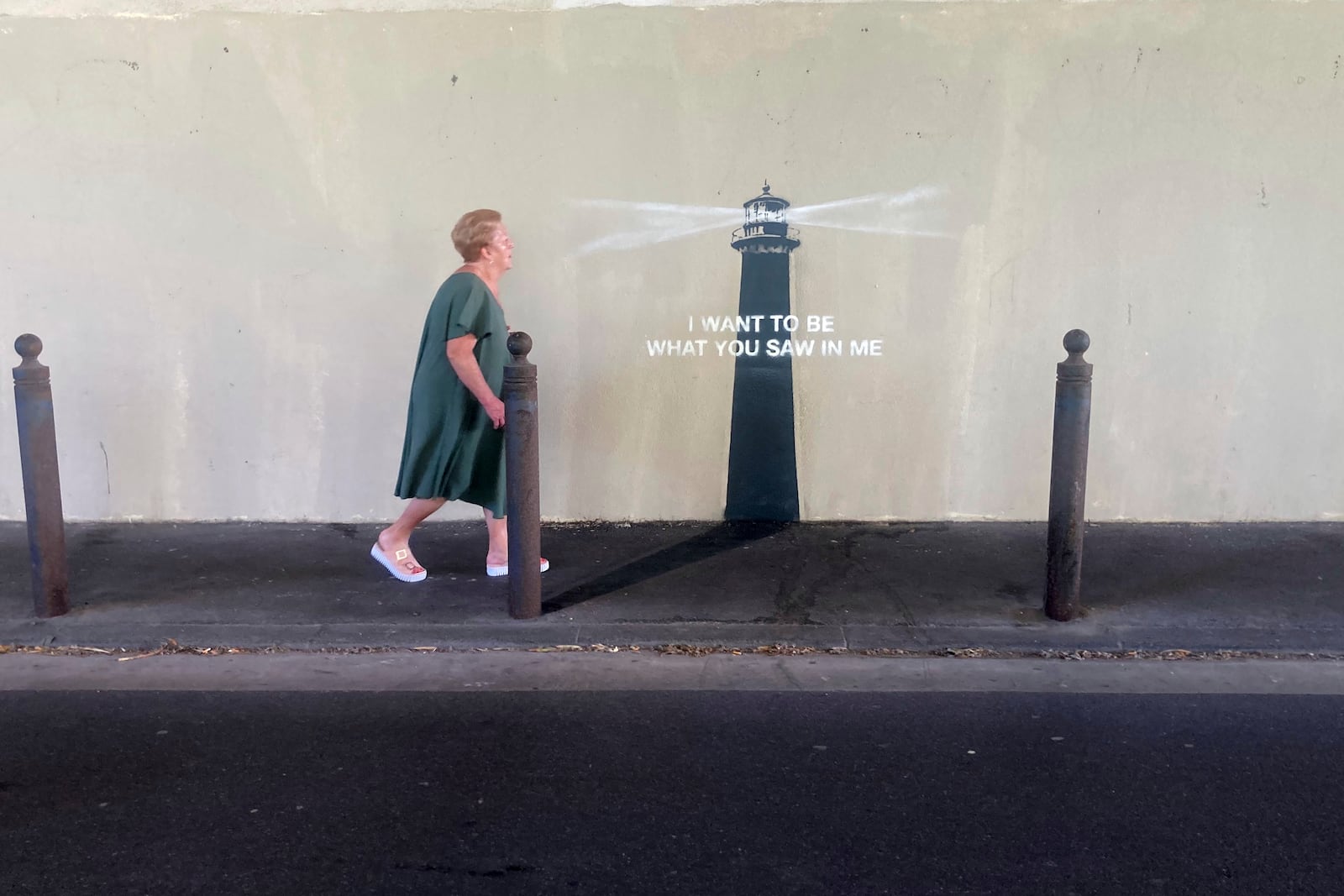 A woman walks past an artwork by street artist Banksy, Friday, May 30, 2025 in Marseille, southern France. (AP Photo/Bishr Eltoni)