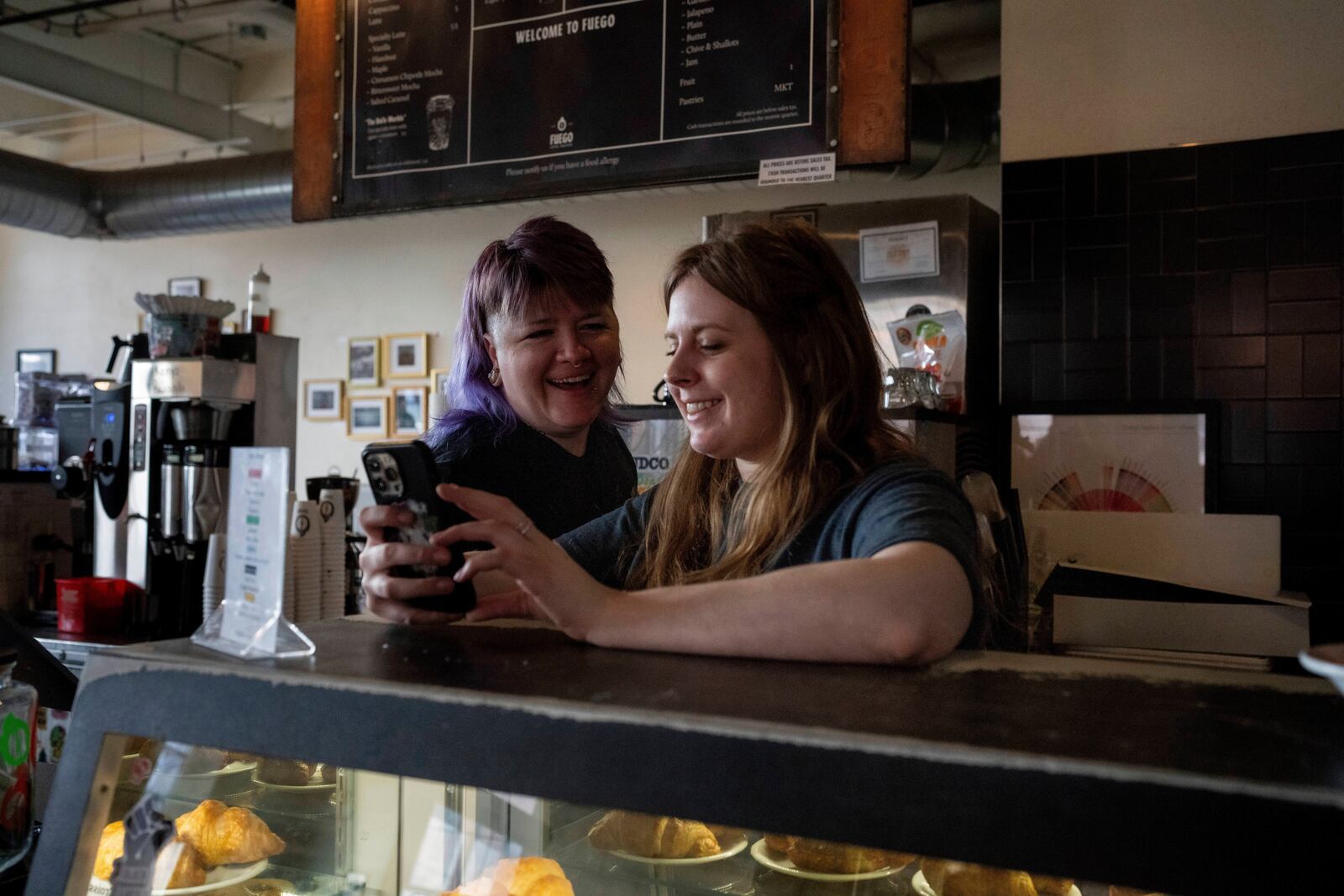 Renee Colon, co-owner of Fuego Coffee Roasters, talks to Claire Terrelli, an employee, Saturday, March 22, 2025, in Rochester, N.Y. (Max Conway via AP)