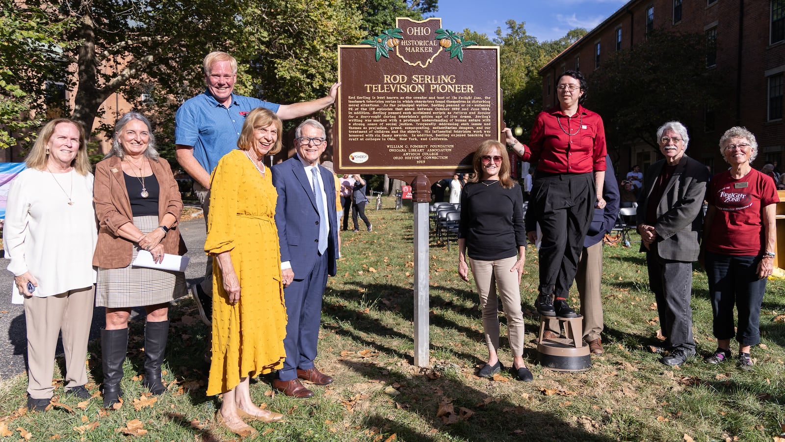 Gov. Mike DeWine and his mother Fran (center left) and Anne Serling (center right) pose with others in front of a historical marker for Rod Serling on Thursday, Oct. 2 at Antioch College in Yellow Springs. Serling is the creator of "The Twilight Zone." He was a student and later returned as a teacher at Antioch. BRYANT BILLING / STAFF