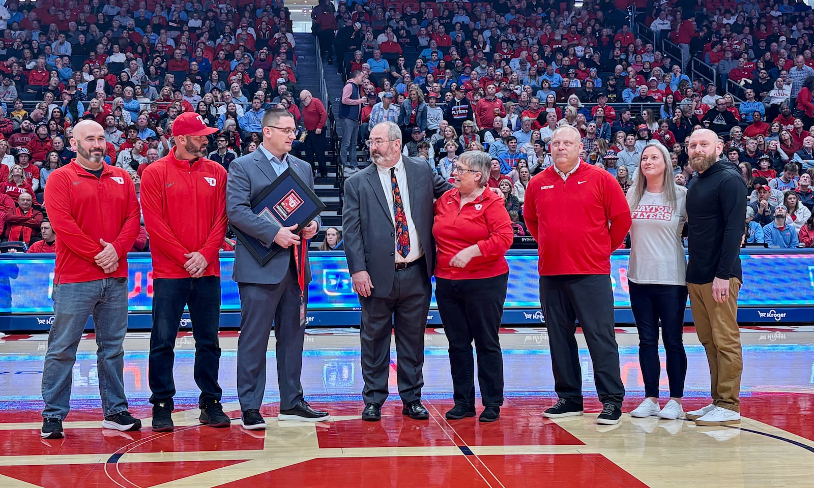 Dayton's Doug Hauschild, who is retiring after the school year, is honored during a timeout in the second half of a game against Loyola Chicago on Saturday, Jan. 18, 2025, at UD Arena. David Jablonski/Staff