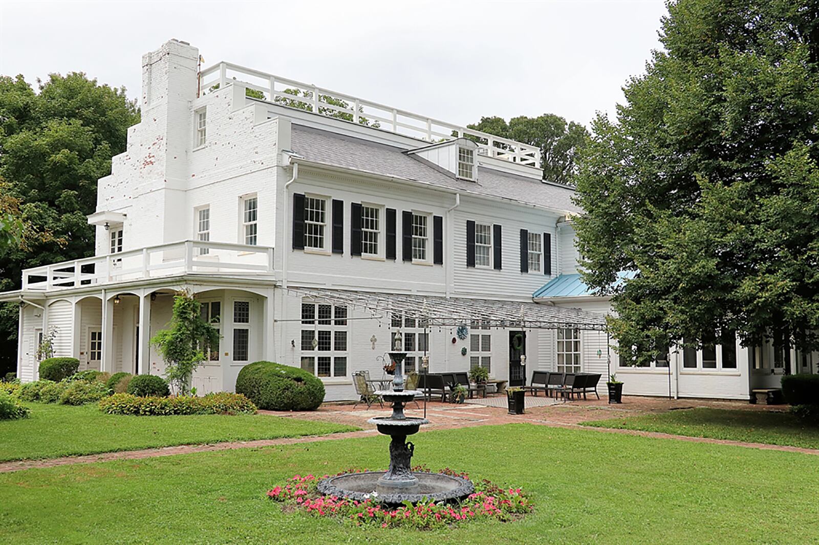 A 4-season sun room has a heated Terrazzo tile floor and two walls of windows that provide panoramic views of the countryside. The patio doors open to a stone patio with compass rose etching and stone wall accents. Off the patio, stone walkways lead to a rock garden and down to a koi pond. CONTRIBUTED PHOTO BY KATHY TYLER