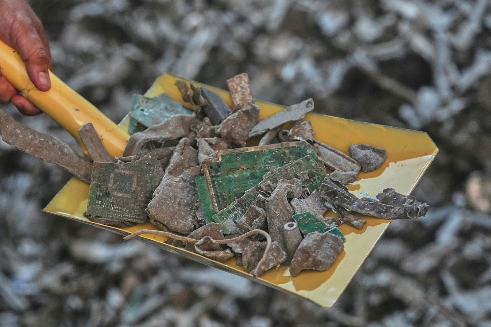 A Thai official shows samples of illegally imported electronic waste from the United States which they said they seized at Bangkok Port during a press conference in Bangkok, Thailand, Wednesday, May 14, 2025. (AP Photo/Sakchai Lalit)