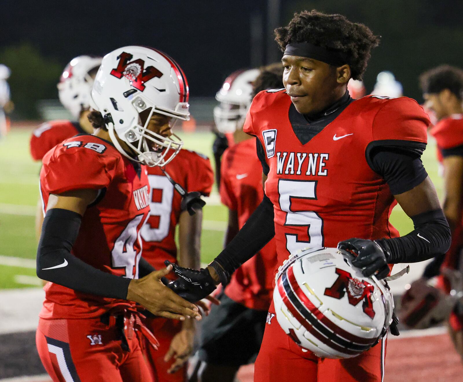 Wayne senior defensive back Sean Heisle is congratulated by Terrence Williams after Heisle returned an interception for a touchdown in the third quarter of a Greater Western Ohio Conference game on Friday, Sept. 12 at Heidkamp Stadium. Heisle intercepted two passes. BRYANT BILLING / STAFF