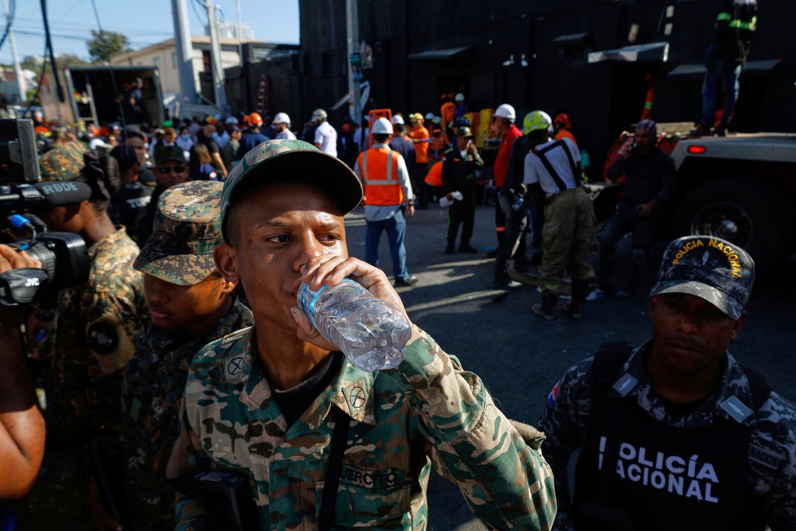 A soldier hydrates while rescue workers search for survivors at the Jet Set nightclub after its roof collapsed during a merengue concert in Santo Domingo, Dominican Republic, Tuesday, April 8, 2025. (AP Photo/Eddy Vittini)