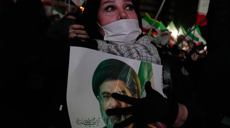 A woman holds a picture of the Iranian Supreme Leader Ayatollah Mojtaba Khamenei during a pro-government gathering in a square in western Tehran, Iran, Wednesday, March 25, 2026. (AP Photo/Vahid Salemi)
