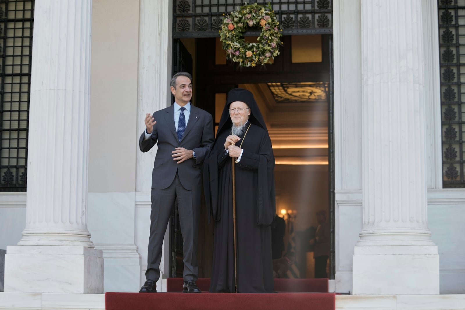 Greece's Prime Minister Kyriakos Mitsotakis, left, and the Orthodox Ecumenical Patriarch Bartholomew pose for photographers before their meeting in Athens, on Thursday May 8, 2025. (AP Photo/Petros Giannakouris)