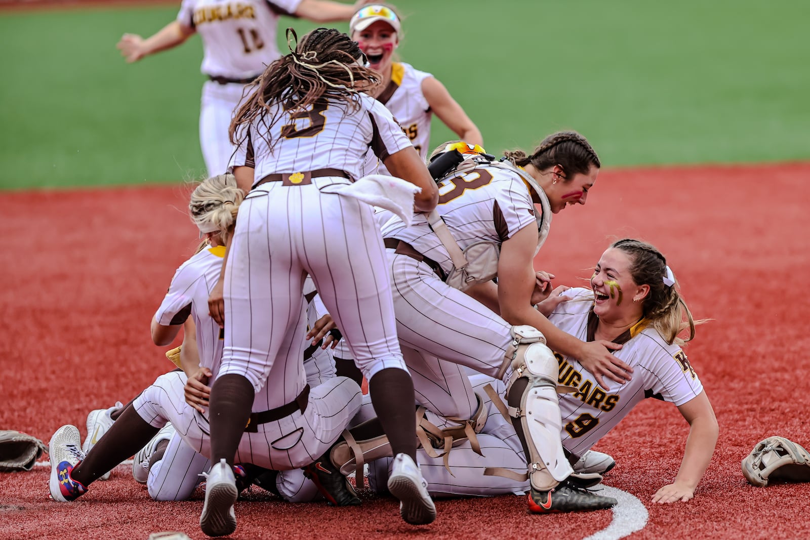 The Kenton Ridge High School team celebrates after getting the last out to win the Division IV state championship game on Thursday, June 5 at Akron's Firestone Stadium. The Cougars beat Hillsboro 9-0. MICHAEL COOPER / STAFF