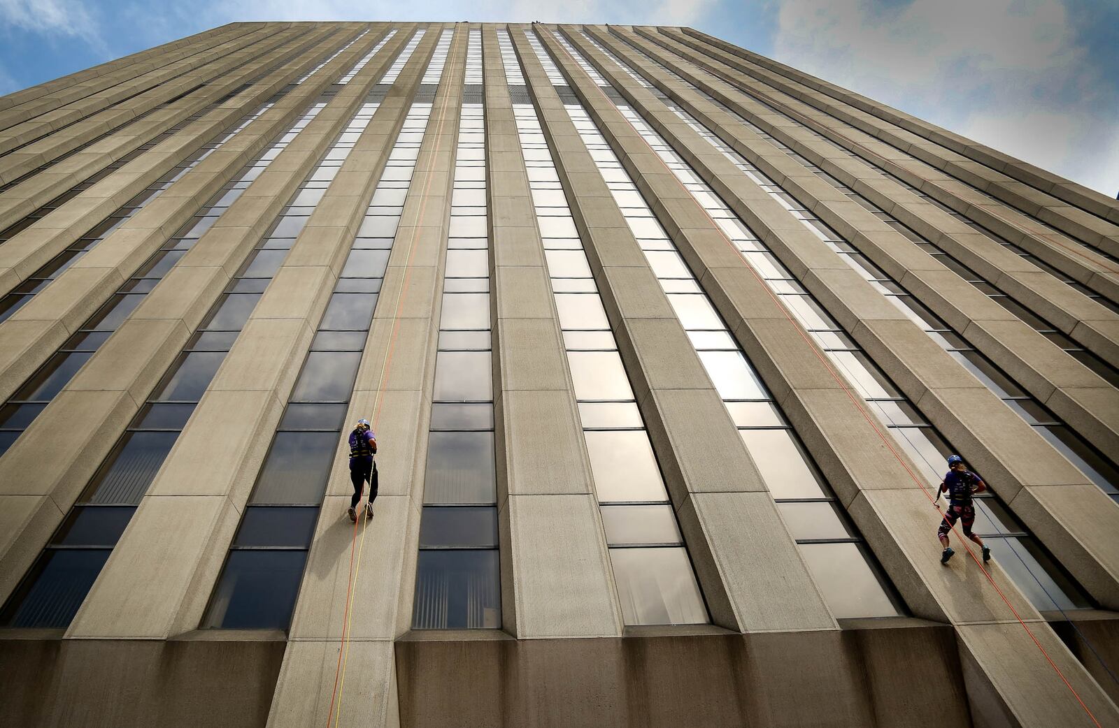 Courtney Cunningham (left) and Sarah Labs descend the 27-story KeyBank Tower on Friday afternoon, Aug. 14, 2015, as part of a unique fundraiser that supports Big Brothers Big Sisters of the Greater Miami Valley. The Over the Edge fundraiser was back for the fifth year with the goal of raising $140,000 in 2015. JIM WITMER/STAFF