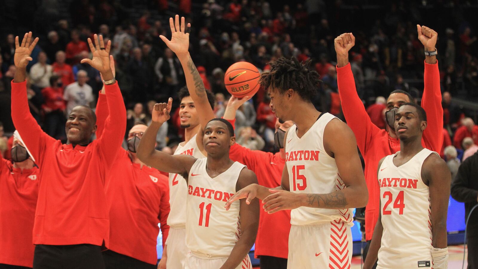 Dayton coach Anthony Grant, left, and players wave to Dayton basketball legend Bucky Bockhorn after a victory against St. Bonaventure on Tuesday, Jan. 18, 2022, at UD Arena. David Jablonski/Staff