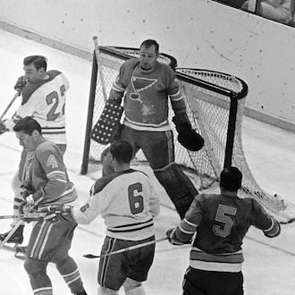 FILE - St. Louis Blues goalie Glenn Hall, top right, is pinned to his net waiting to make a save on a Montreal Canadians shot as Blues' Noel Picard (4) tries to block the puck while Canadiens' John Ferguson (22) and Ralph Backstorm wait for a rebound in the third period of their NHL hockey Stanley Cup game, May 5, 1968. (AP Photo/Fred Waters, File)