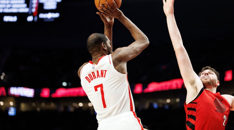 Houston Rockets forward Kevin Durant, left, shoots over Portland Trail Blazers center Donovan Clingan, right, during the second half of an NBA basketball game Friday, Jan. 9, 2026, in Portland, Ore. (AP Photo/Howard Lao)