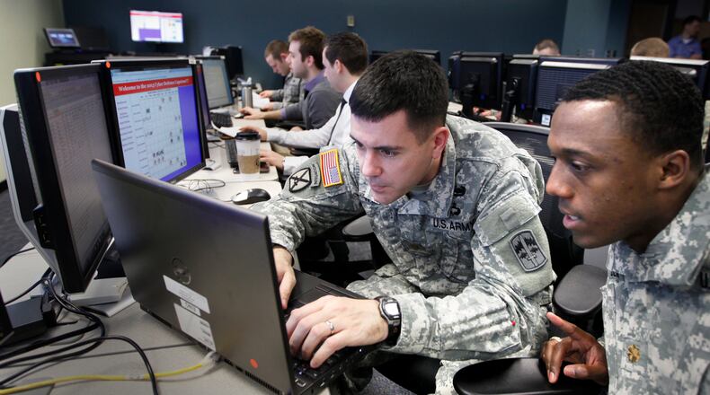 U.S. Army Majors Paul Williams, left, and Brian Beam competed in the Air Force Institute of Technology Cyber Defense and Exploitation Capstone Exercise as part of their graduate studies on Wednesday, February 20. The Cyber Defense Capstone exercise is a timed competition event between four teams consisting of four competition components. These component areas, or individual cyber defense exercises, involve scenarios based on: asset acquisition-defense-analysis, capture-the-flag, username/password, and unit mission. TY GREENLEES / STAFF
