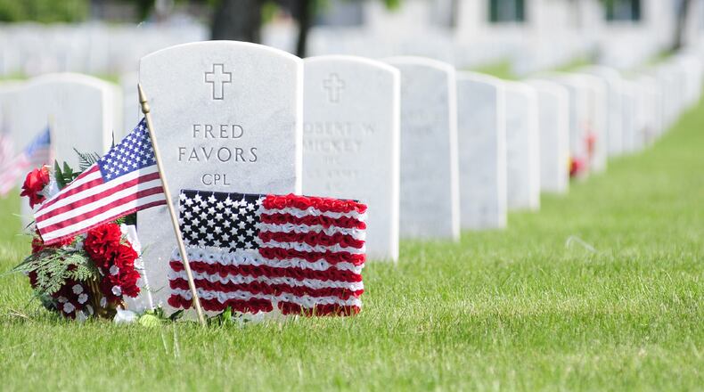 In this file photo, decorations are placed during a Memorial Day Ceremony held Monday May 27, 2013 at the Dayton National Cemetery Photo by Charles Caperton
