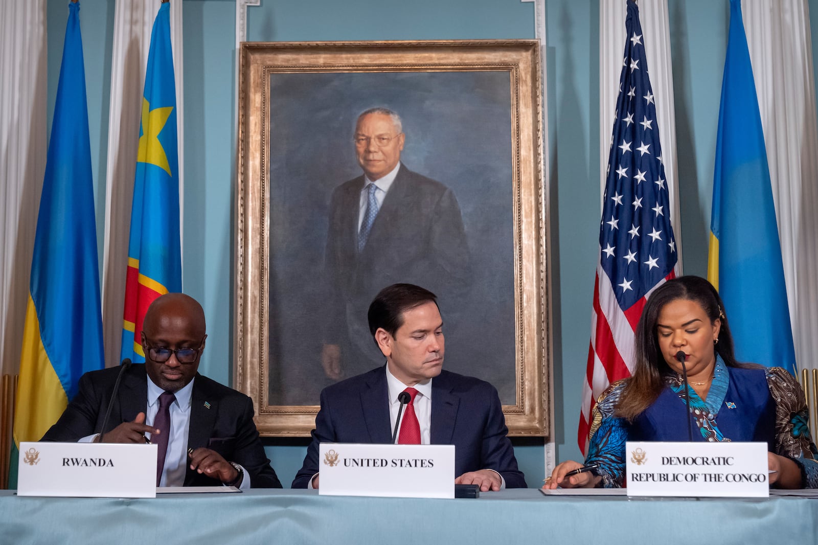 Secretary of State Marco Rubio, center, watches as Rwanda's Foreign Minister Olivier Nduhungirehe, left, and Democratic Republic of the Congo's Foreign Minister Therese Kayikwamba Wagner, right, sign a peace agreement at the State Department, Friday, June 27, 2025, in Washington. (AP Photo/Mark Schiefelbein).