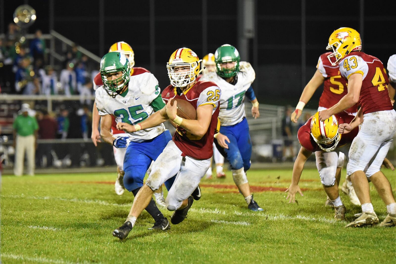 Fenwick’s Logan Miller (26) breaks through the line as Chaminade Julienne’s David Frederick (35) gives chase Friday night at Krusling Field in Middletown. The host Falcons won 34-19. CONTRIBUTED PHOTO BY ANGIE MOHRHAUS