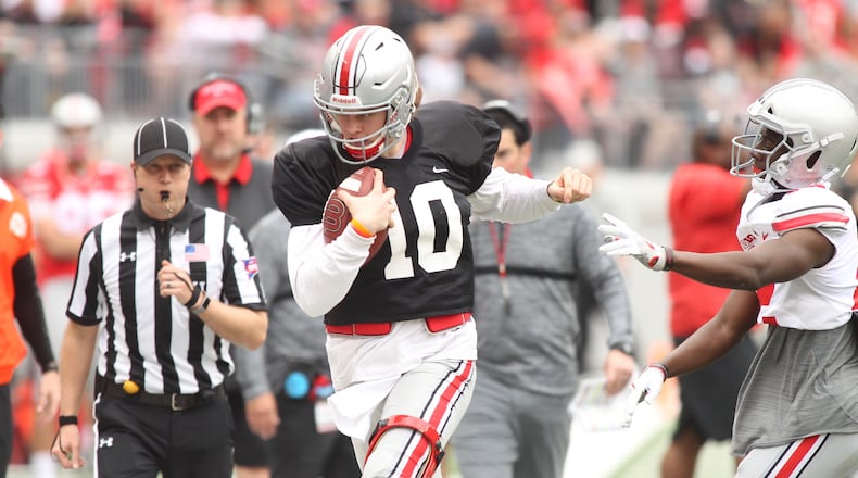 Ohio State’s Joe Burrow, left, is pushed out of bounds during the spring game on Saturday, April 14, 2018, at Ohio Stadium in Columbus. David Jablonski/Staff