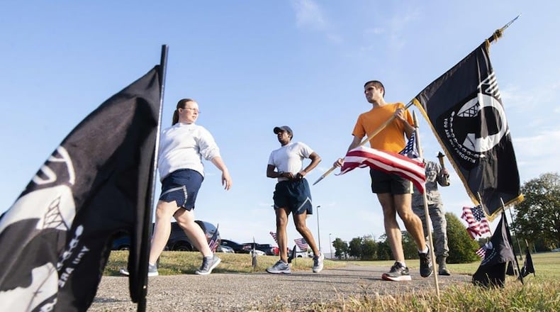 Airmen carry the POW/MIA torch and flag around the Air Force Research Laboratory track during the 2019 POW/MIA Run at Wright-Patterson Air Force Base Sept. 19. During the run, volunteers keep the torch and flag continuously moving for 24 straight hours in remembrance of those service members captured or missing. (U.S. Air Force photo/Wesley Farnsworth)