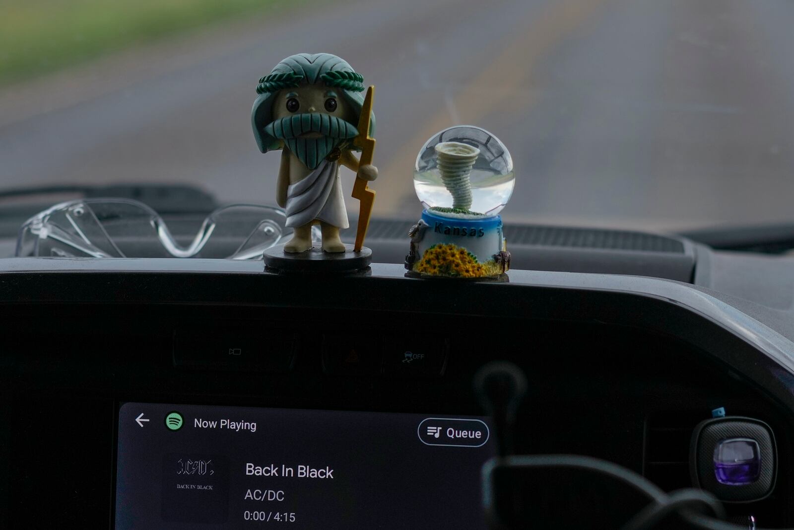 Dashboard mascots Zeus, left, and Tor, right, sit in a car as AC/DC's “Back in Black” plays on the stereo in Northern Illinois University's Husky Hail Hunter vehicle, as they drive into a storm during a Project ICECHIP operation, Friday, June 6, 2025, near Levelland, Texas. (AP Photo/Carolyn Kaster)