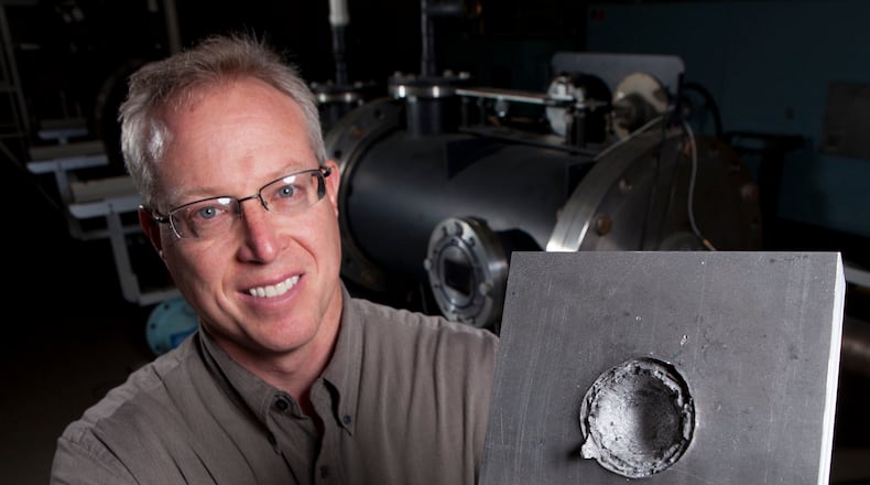 The University of Dayton is among the top three universities in the nation when it comes to sponsored materials research, the university said Tuesday. UD Research Institute senior impact physics engineer Kevin Poormon displays an aluminum block that was struck by a projectile sphere like the one between his fingers in this 2014 photo. TY GREENLEES / STAFF