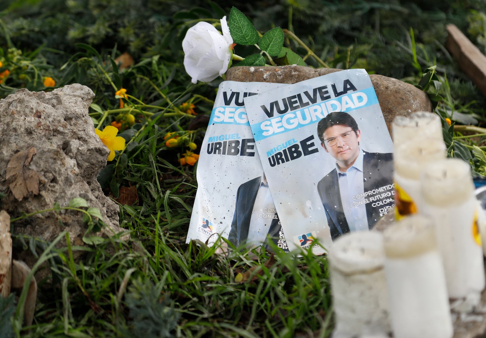 Images of Colombian Senator Miguel Uribe Turbay, along with candles and flowers, lay at the site where he was shot during a political rally in Bogota, Colombia, Monday, June 9, 2025. (AP Photo/John Vizcaino)