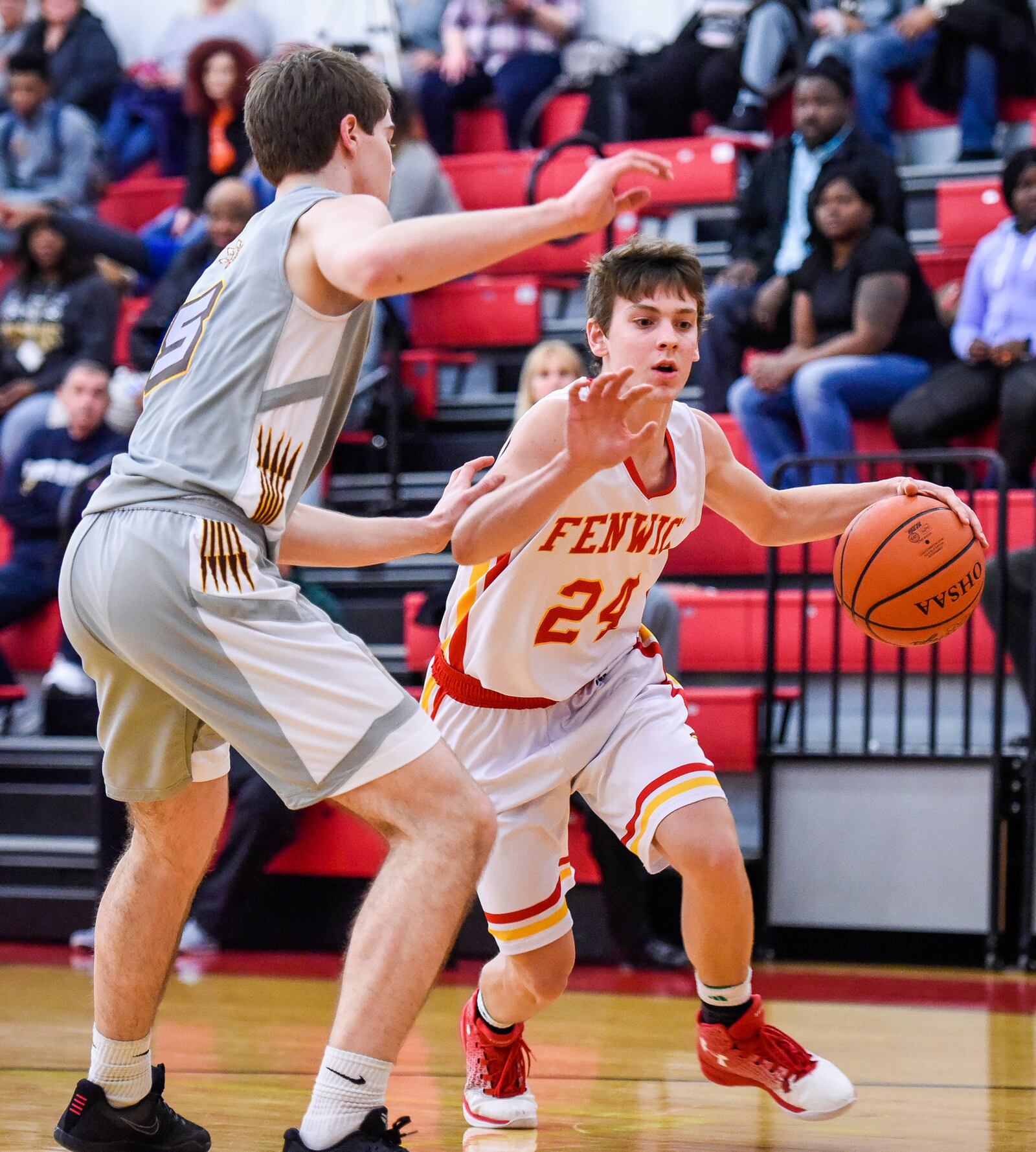 Fenwick's David Luers dribbles to the basket while being defended by Roger Bacon's Alec Pfriem during Friday night’s game at Fenwick. NICK GRAHAM/STAFF