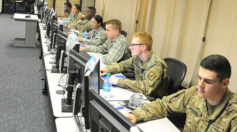 The eyes of Team Alpha’s seven Army and Air Force ROTC cadets are glued to their dual monitors as they prepare their two virtual computer systems’ defenses and navigate network structures during the Air Force Institute of Technology’s Advanced Cyber Education program here. The program hosted 45 Air Force and Army ROTC cadets and split them into seven green-blue teams, putting each team through a wide variety of cybersecurity related disciplines to develop original thinkers and technical leaders who will be prepared to solve real-world problems in the area of cybersecurity. (U.S. Air Force photo/John Van Winkle)