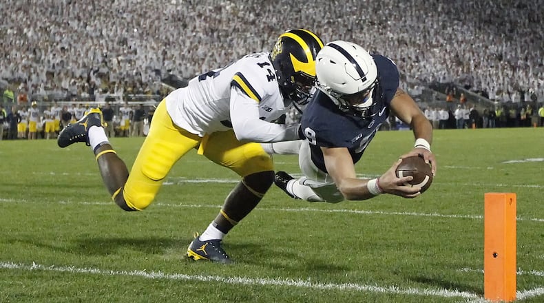 Penn State quarterback Trace McSorley (9) dives for a touchdown as Michigan’s Josh Metellus (14) defends during the second half in State College, Pa., Saturday, Oct. 21, 2017. Penn State won 42-13. (AP Photo/Chris Knight)