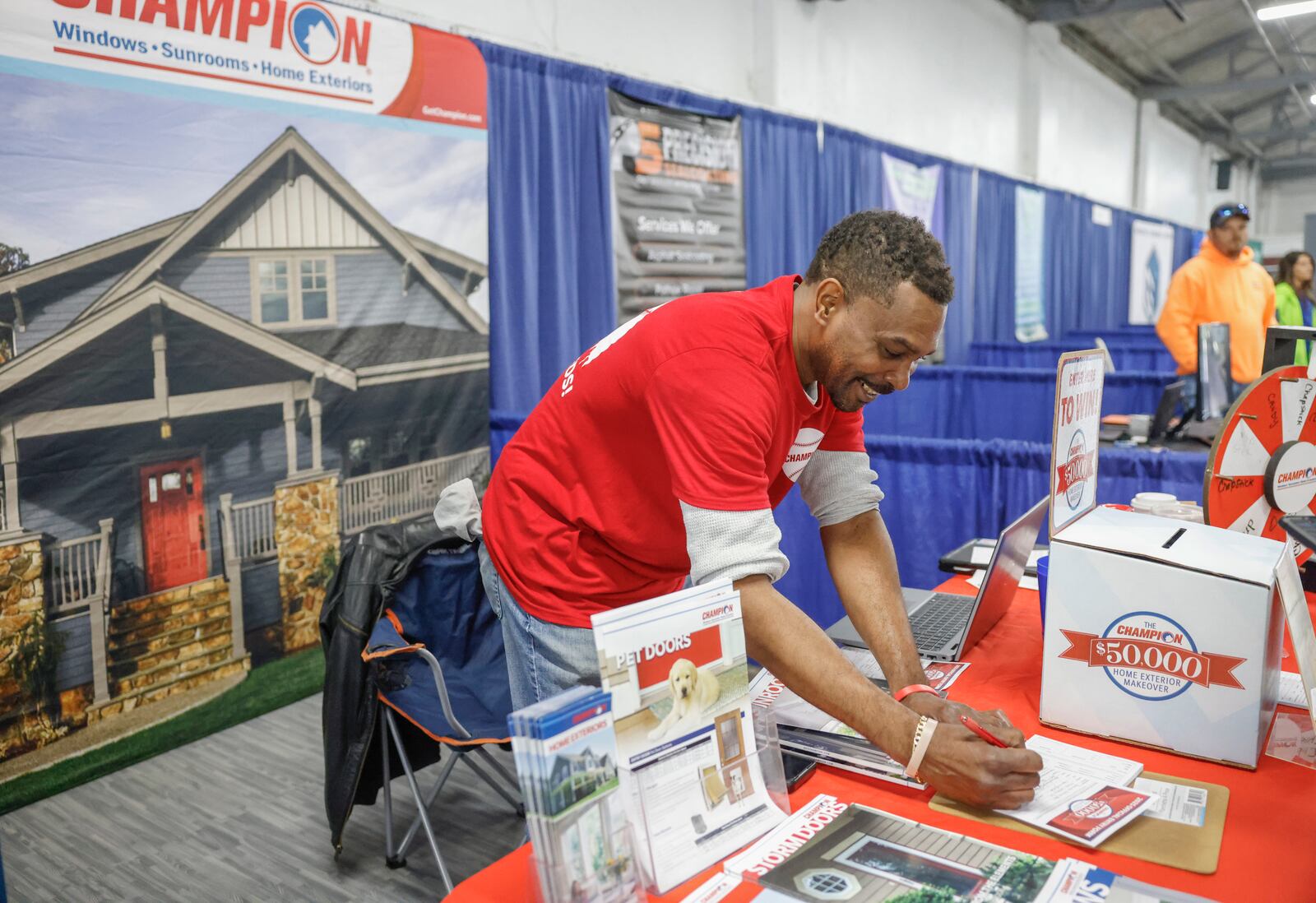 Mike Washington, field marketing manager of Champion Windows, of Cincinnati, writes information for a customer visiting his booth during the Clark County Home and Garden Show. JOSEPH COOKE/STAFF