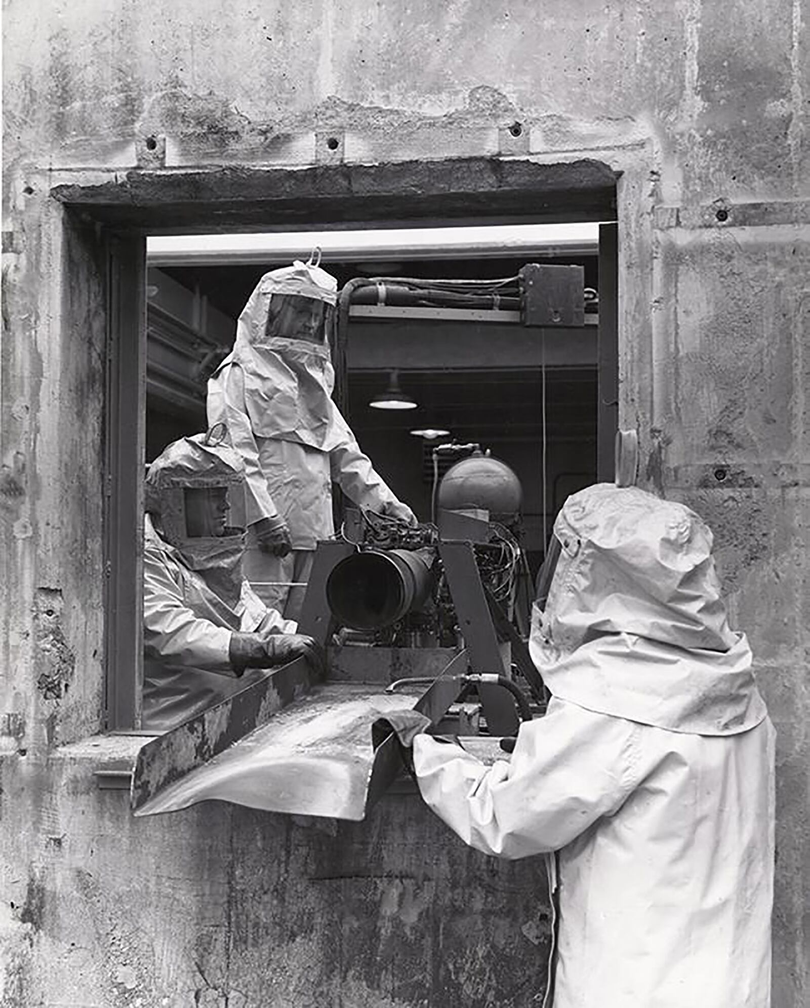 This picture is unfortunately not dated, but it shows what appears to be several scientists inspecting a rocket engine. This engine appears to be one that uses a type of rocket fuel that is very corrosive to human tissue, as evidenced by the chemical suits worn by the scientists. DAYTON DAILY NEWS ARCHIVES