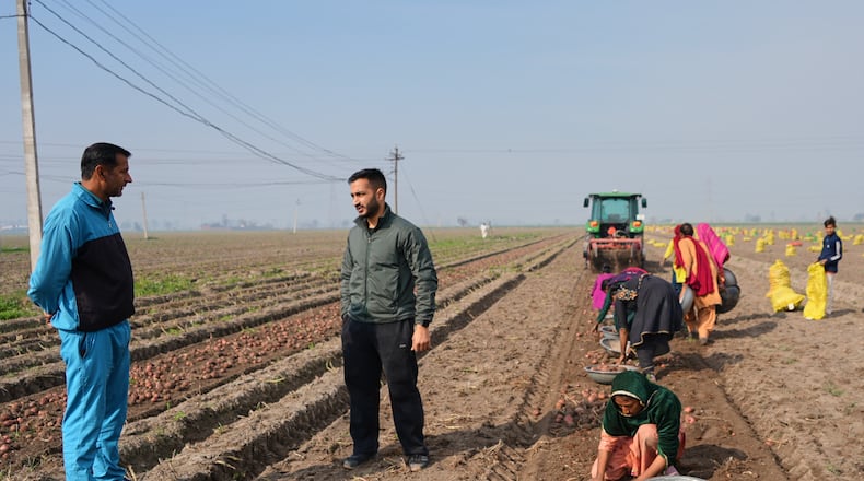 Indian farmer Bir Virk, second left, talks with his neighboring farmer about using AI, or Artificial Intelligence technology in farming, near Karnal, India, on Feb. 10, 2026. (AP Photo/Piyush Nagpal)