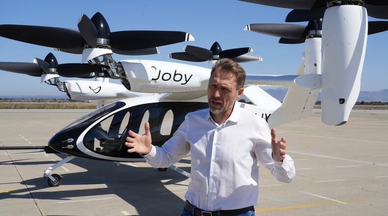 JoeBen Bevirt, CEO of Joby Aviation, stands next to an "electric vertical take-off and landing" aircraft, also known as an eVTOL, in Marina, Calif. on Monday, Oct. 7, 2024. (AP Photo/Terry Chea)